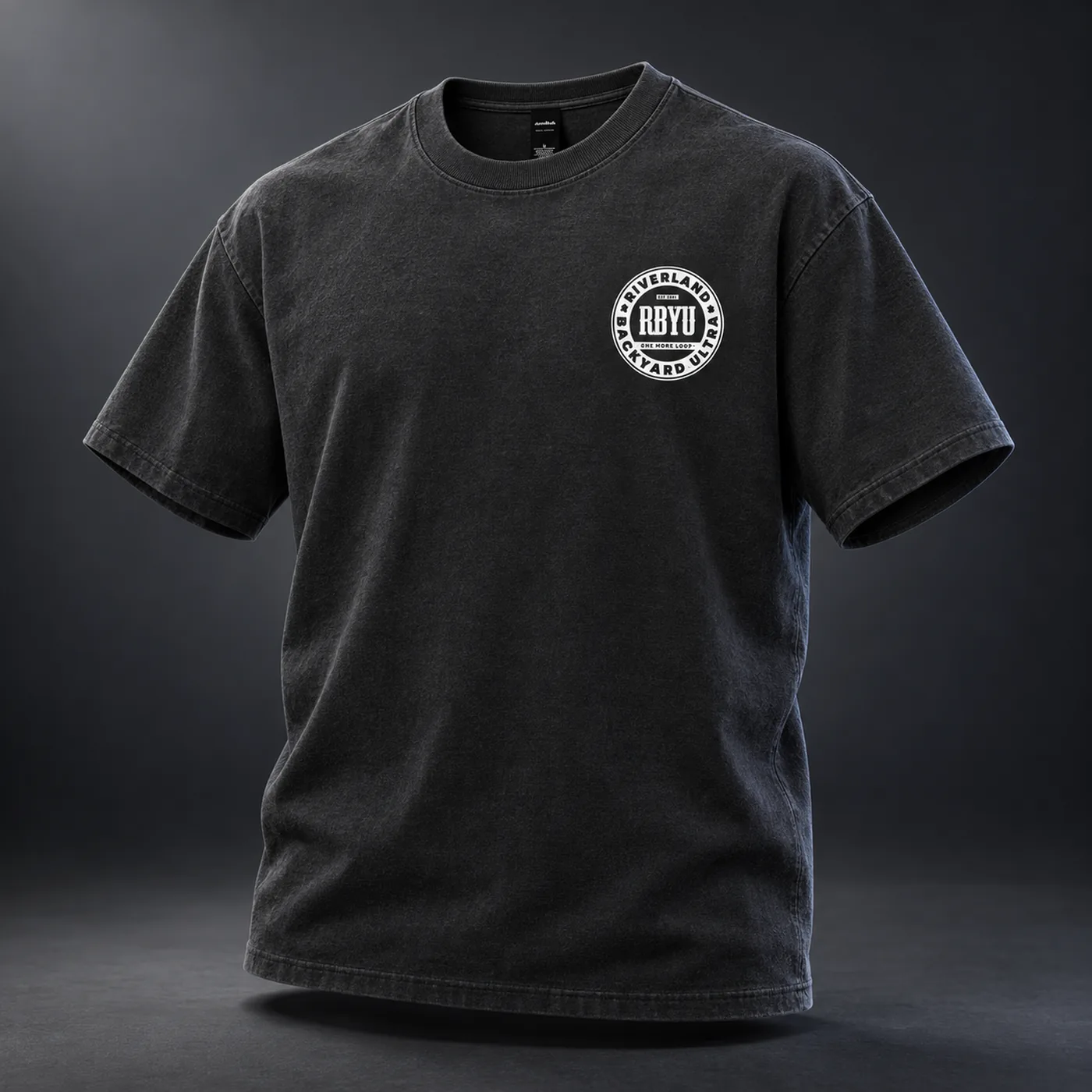 Front view of the faded black heavyweight tee with the white circular RBYU badge printed on the left chest.